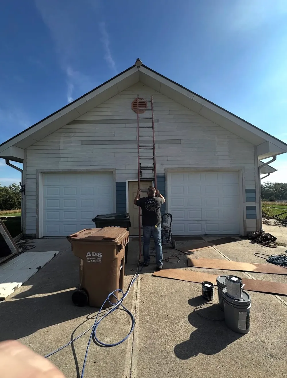 Before — weathered white garage being prepped for paint